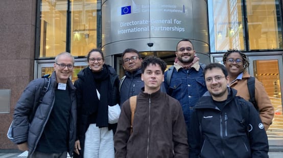 Photo de groupe de 7 personnes devant l’entrée du bâtiment de la Direction générale des partenariats internationaux à Bruxelles